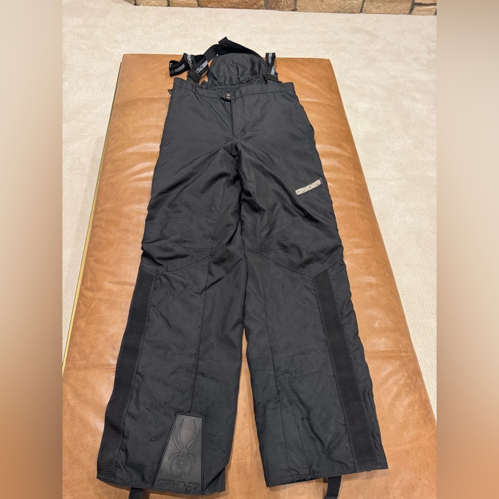 Spyder men’s ski pants with suspenders color black. Used with some visible wear